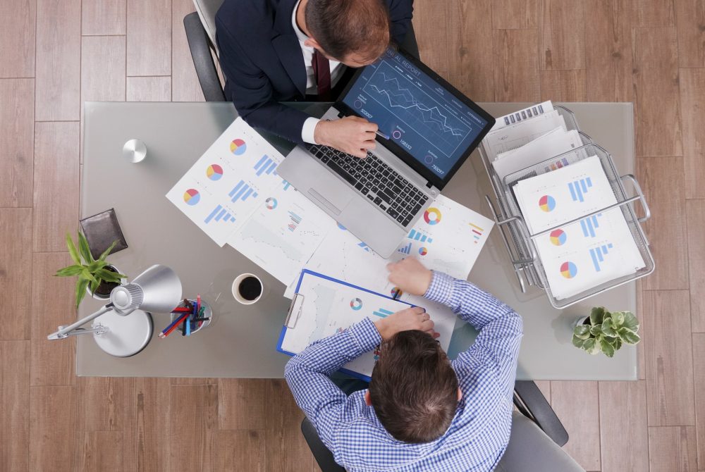 top-view-of-businessmen-analyzing-management-statistics-while-working-at-company-investments.jpg